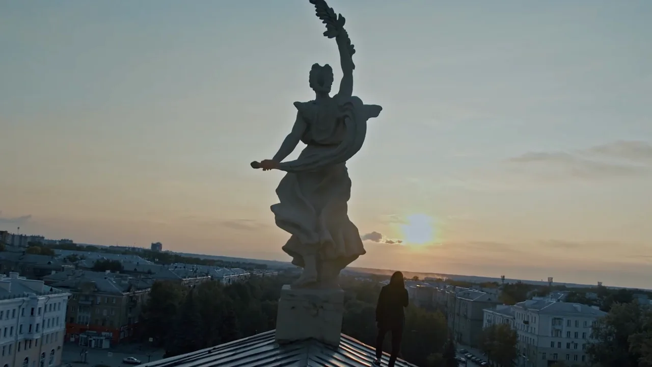 Скульптура на крыше ДК на закате, рядом герой